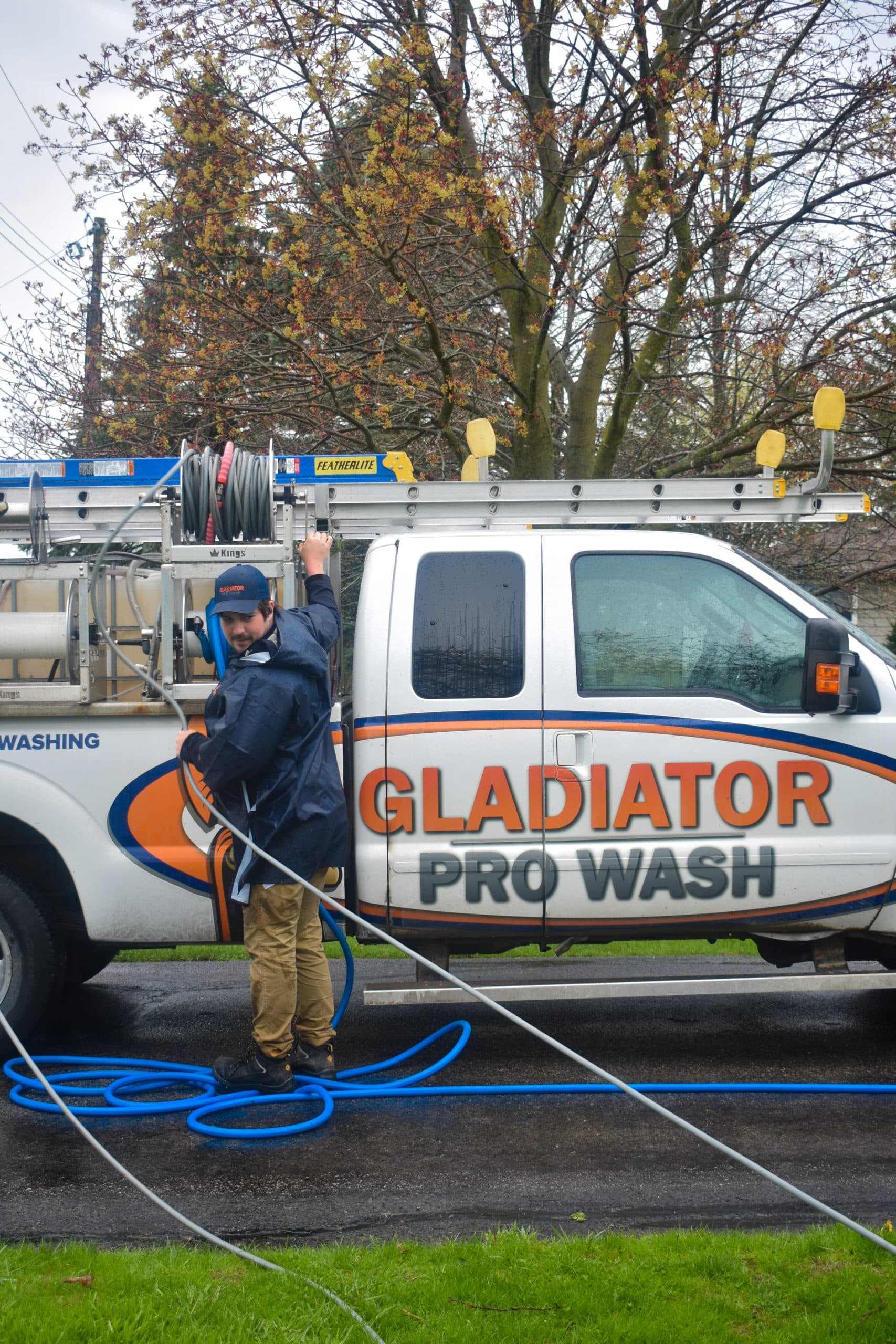 A technician pulling hose from a Gladiator Pro Wash pickup with ladder rack