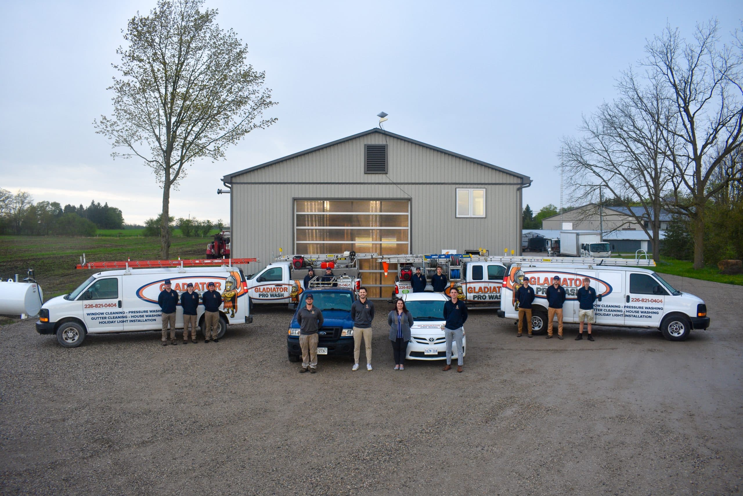 The full Gladiator Pro Wash crew and fleet lined up outside the company shop at dusk