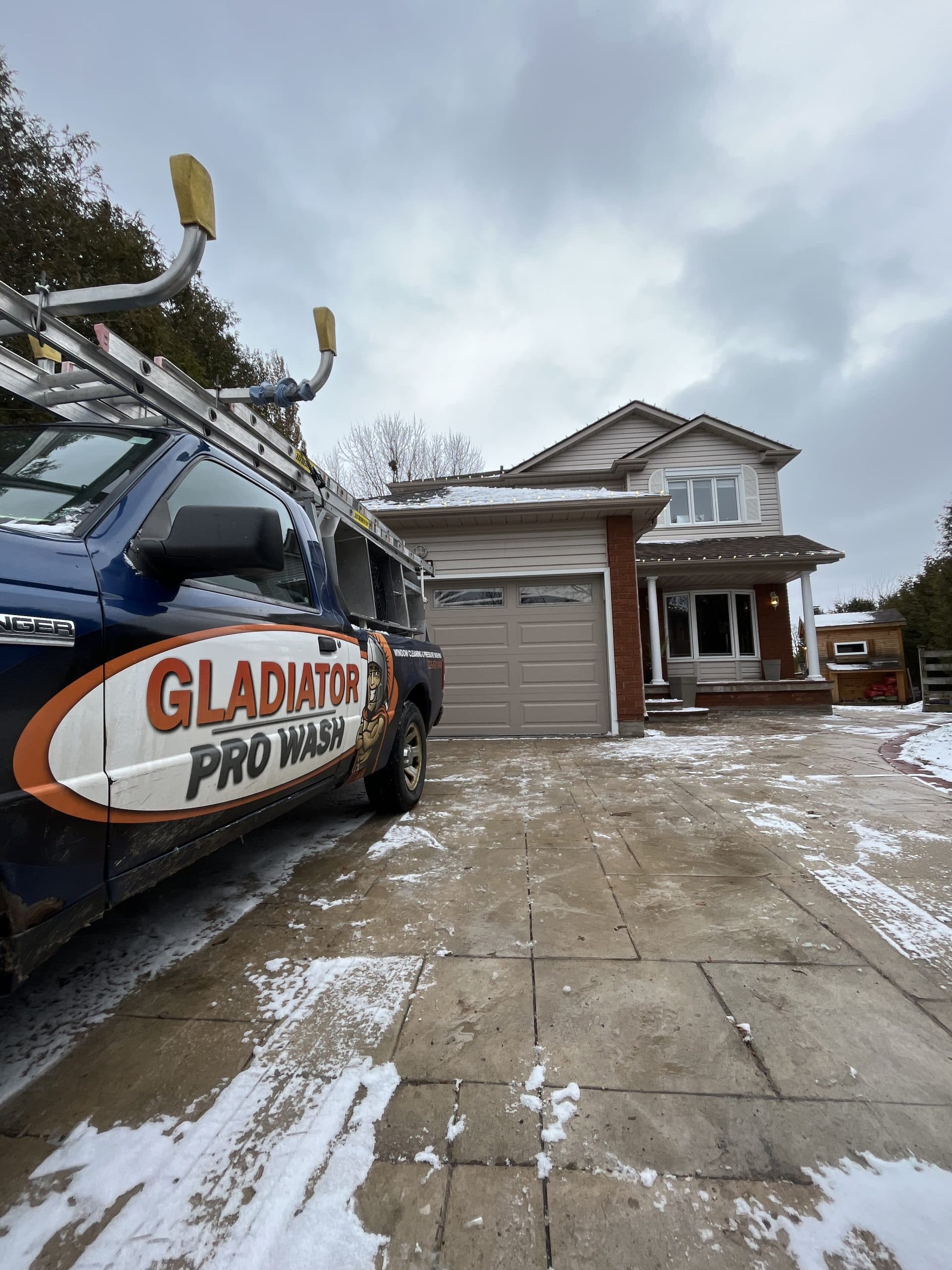 A Gladiator Pro Wash truck parked at a snowy driveway